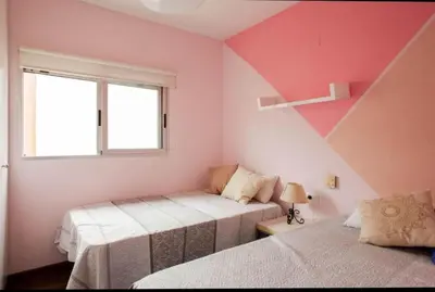 two beds in a room with pink and white walls at Valencia luxury in Valencia