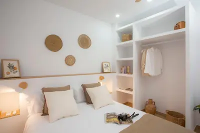 a bedroom with a white bed with white pillows and shelves at Casa La Pedrera in Pedralba