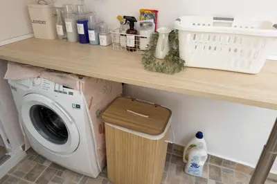 a shelf above a washing machine under a counter at Casa La Pedrera in Pedralba