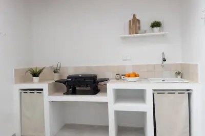 a kitchen with white counters and a black grill at Casa La Pedrera in Pedralba