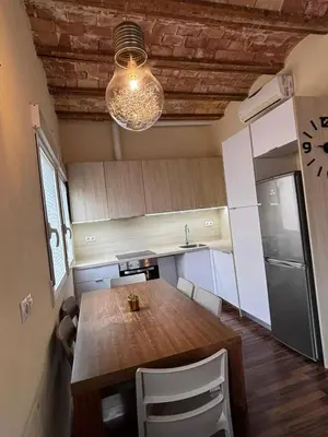 a kitchen with a wooden table and aendant light at Moderno Apartamento Cerca del Centro y la Playa in Valencia
