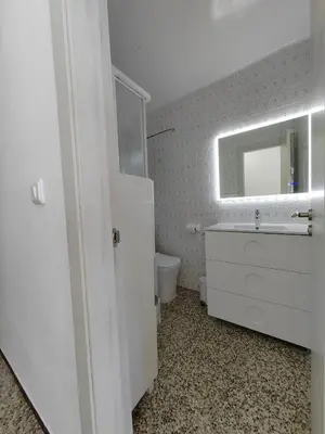 a white bathroom with a sink and a mirror at Vistal Mar in Puerto de Sagunto
