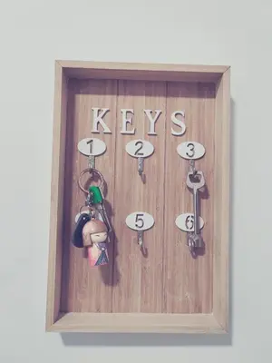 a wooden clock with keys hanging on a wall at Vistal Mar in Puerto de Sagunto
