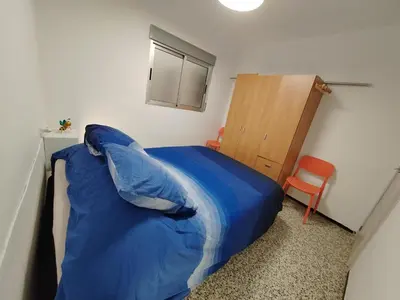 a bedroom with a bed with a blue blanket at Vistal Mar in Puerto de Sagunto