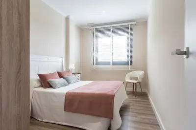 a white bedroom with a bed and a window at White House with MINIGOLF 10 minutes from Cullera in Corbera de Alcira