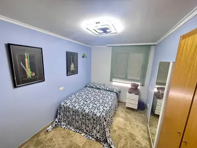 a bedroom with a bed in a room with blue walls at Sientete como en casa in Sedaví