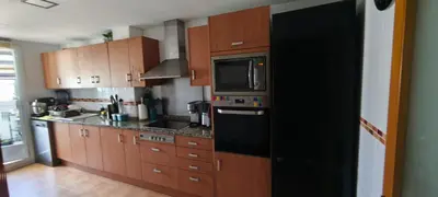 a kitchen with a black refrigerator and wooden cabinets at Sientete como en casa in Sedaví