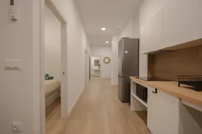 a kitchen with white walls and a long hallway at Comfortabel Apartment next to La Marina in Valencia