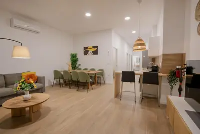 a living room and kitchen with a couch and a table at Comfortabel Apartment next to La Marina in Valencia