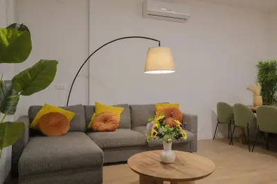 a living room with a couch and a table with flowers at Comfortabel Apartment next to La Marina in Valencia