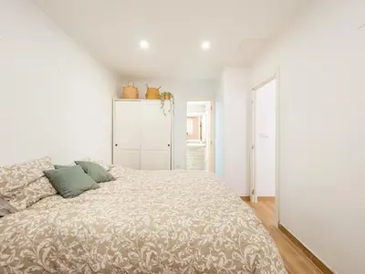 a bedroom with a large bed in a white room at Vivienda junto al Mercado Central in Valencia