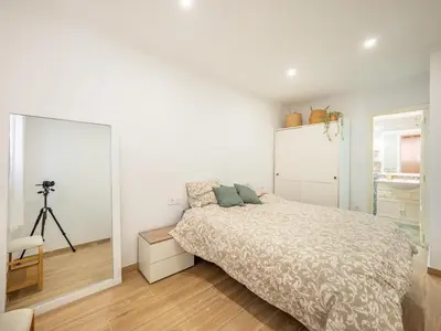 a white bedroom with a bed and a camera at Vivienda junto al Mercado Central in Valencia