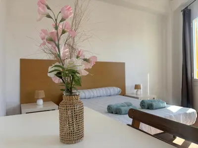 a vase with pink flowers on a table in a bedroom at Urban Stay Valencia - Primado Reig in Valencia