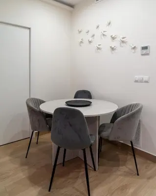 a white table with four chairs and a white wall at Viva Valencia Apartments - Arte & Reflejos in Valencia