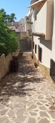 an alley with a bench next to a building at Clau al castell apartament in Serra