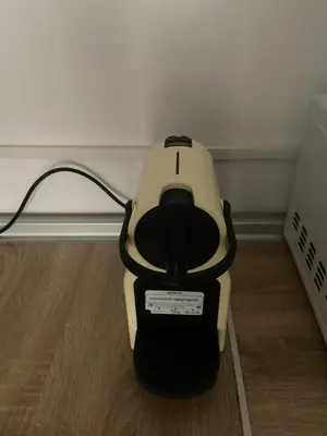 a yellow and black vacuum sitting on a wooden floor at Clau al castell apartament in Serra