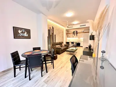 a dining room and living room with a table and chairs at Joaquin Costa Urban Flat in Valencia
