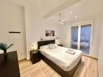 a bedroom with a large bed and a large window at Joaquin Costa Urban Flat in Valencia