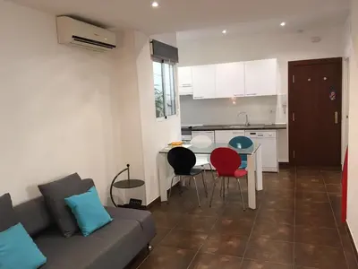 a living room with a couch and a table with chairs at Casa Cosy 2 in Valencia