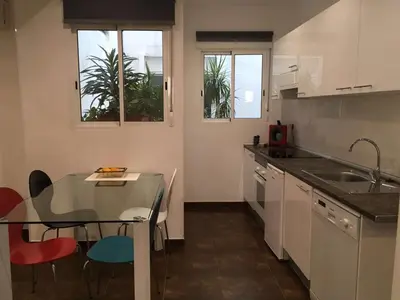 a kitchen with a glass table and red chairs at Casa Cosy 2 in Valencia
