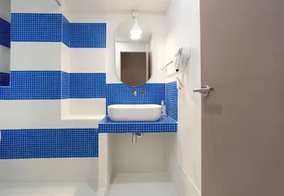 a blue and white bathroom with a sink and a mirror at Cabanyal Rooms by VLC Host in Valencia