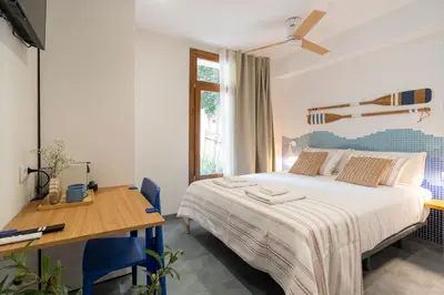 a bedroom with a bed and a desk and a table at Cabanyal Rooms by VLC Host in Valencia