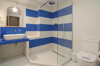 a blue and white bathroom with a sink and a shower at Cabanyal Rooms by VLC Host in Valencia