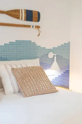 a bed with a pillow and a surfboard on the wall at Cabanyal Rooms by VLC Host in Valencia