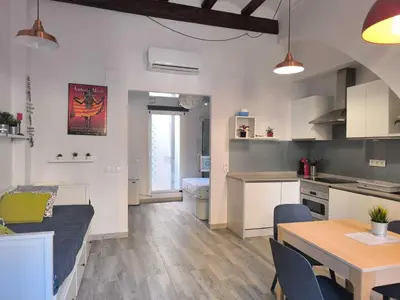 a kitchen and living room with a couch and a table at Encantador Loft Cabañal · Playa Las Arenas in Valencia