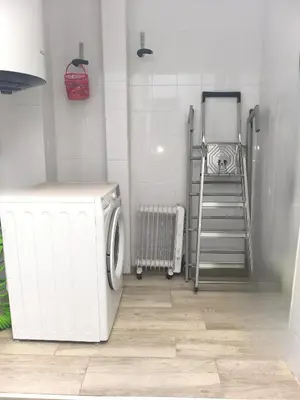 a laundry room with a washing machine and a ladder at Encantador Loft Cabañal · Playa Las Arenas in Valencia