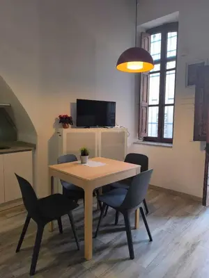 a dining room with a table and chairs and a television at Encantador Loft Cabañal · Playa Las Arenas in Valencia