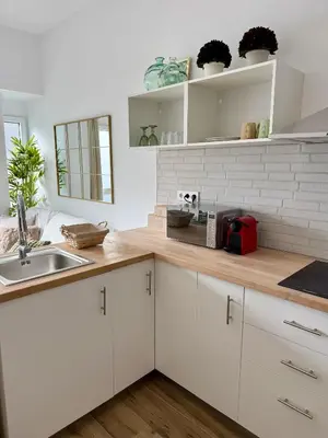 a kitchen with white cabinets and a wooden counter top at Loft acogedor y luminoso in Valencia