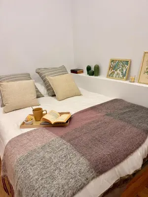 a bed with two books and a tray with books at Loft acogedor y luminoso in Valencia