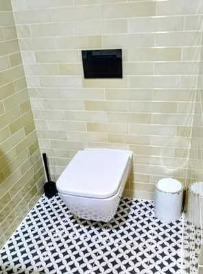 a bathroom with a toilet and a black and white tiled floor at Casa Yaiza in Valencia