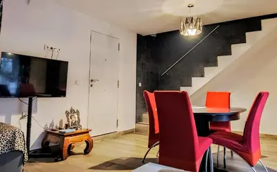 a living room with a table and red chairs at Casa Yaiza in Valencia