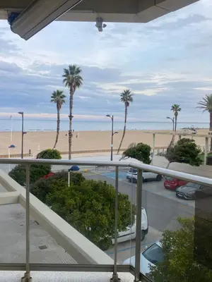 a view of a parking lot with palm trees and a beach at Apartamento en primera línea de playa 38 in Valencia