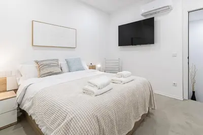 a white bedroom with a bed with towels on it at Modern & Stylish Apartment Close to the Beach in Valencia
