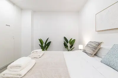 a white bedroom with a bed with towels on it at Modern & Stylish Apartment Close to the Beach in Valencia