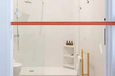 a bathroom with a shower with an orange measuring tape at Modern & Stylish Apartment Close to the Beach in Valencia