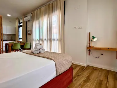 a bedroom with a large white bed with a window at Travel Habitat Santo Domingo Loft in Valencia