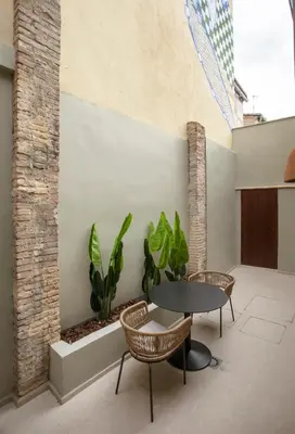a room with a table and chairs and a plant at Mon Suites San Pedro in Valencia