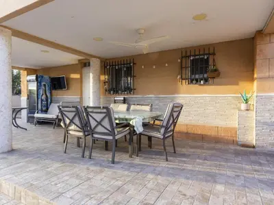 a patio with a table and chairs and a bar at Winahost Villa Unión in Puebla de Vallbona
