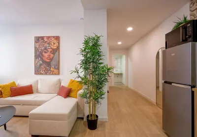 a living room with a white couch and a refrigerator at Casa Estrellita Boutique Apartment in Valencia