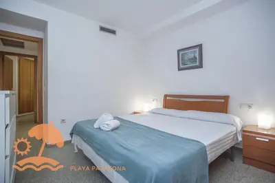 a bedroom with two beds and a table and a chair at Holiday Mare Nostrum in Valencia