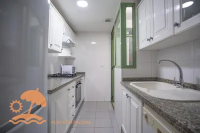 a white kitchen with a sink and a counter at Holiday Mare Nostrum in Valencia