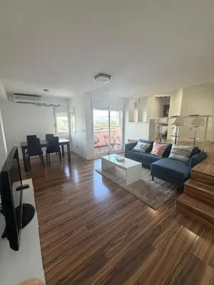a living room with a blue couch and a table at Malvarrosa Penthouse 4 rooms, suite, terrace and balcony in Valencia