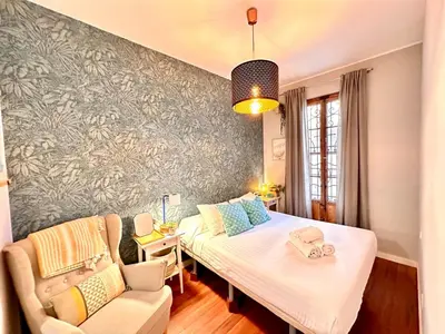 a bedroom with a bed and a couch and a chair at Padre Anton seasonal apartment in Valencia