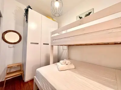 a small bedroom with a bunk bed and a ladder at Padre Anton seasonal apartment in Valencia