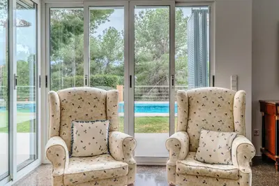 two chairs in a living room with windows at Villa Azahar - Mediterranean Retreat in Benifayó