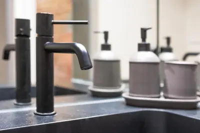 a kitchen counter with a sink with a row of bottles at Borrull Historic Center Premiere in Valencia